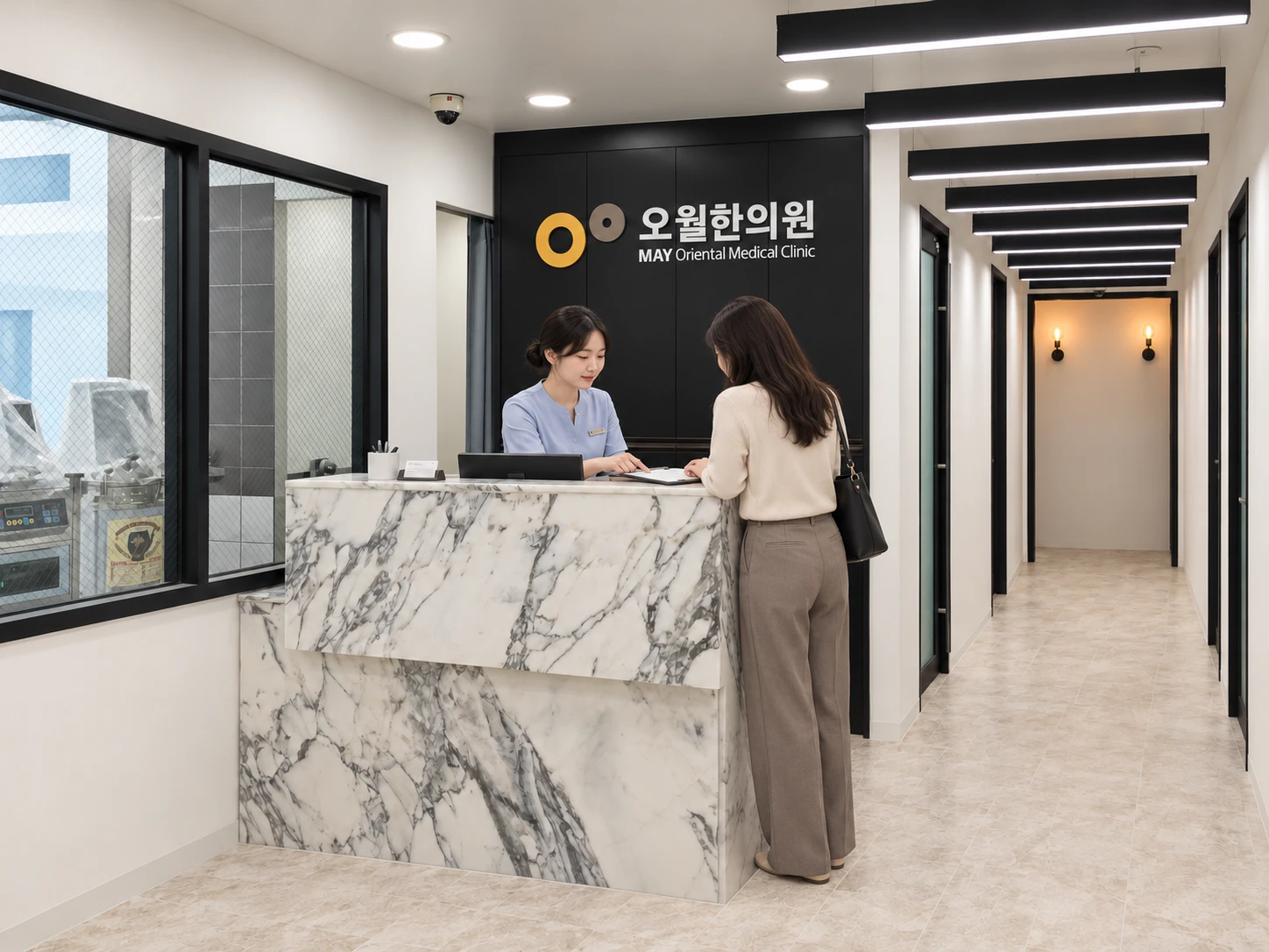 A visitor checking in with the receptionist at May Oriental Clinic.