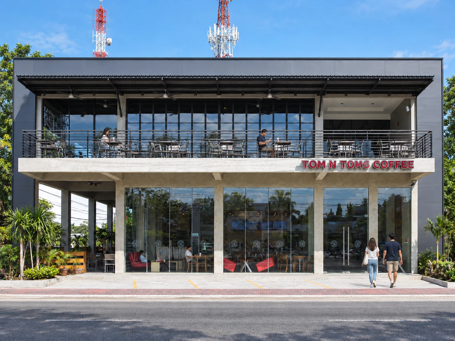 Customers arriving at the Tom and Toms café, with occupied tables on the upper balcony.